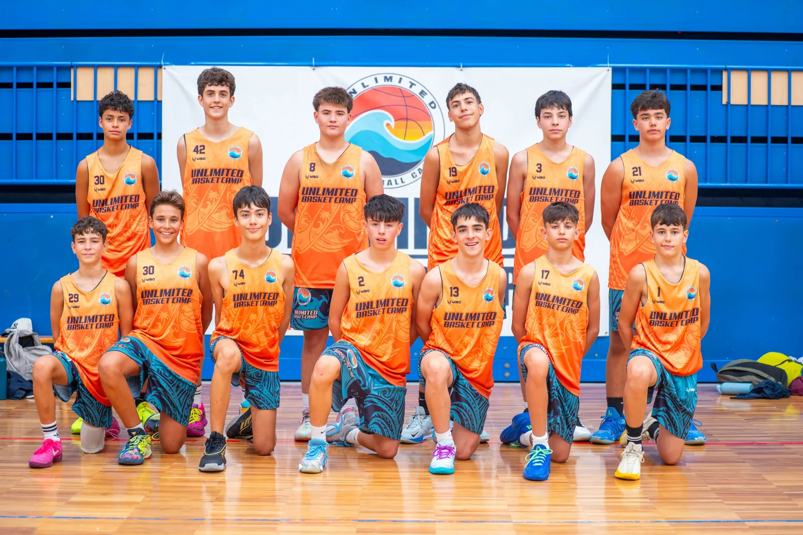 Grupo de jugadores con sus entrenadores delante del photocall