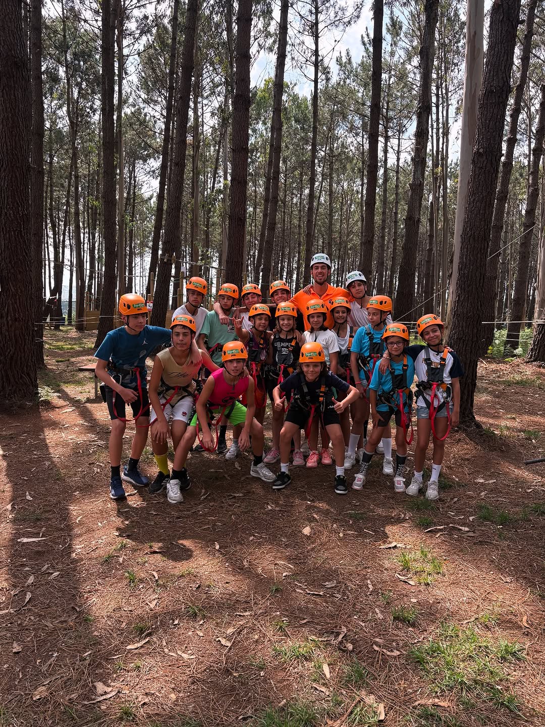 Grupo del campus con gorras naranjas en un pinar