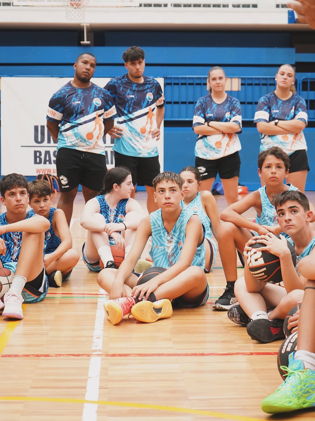 Jugadores y entrenadores sentados en la pista