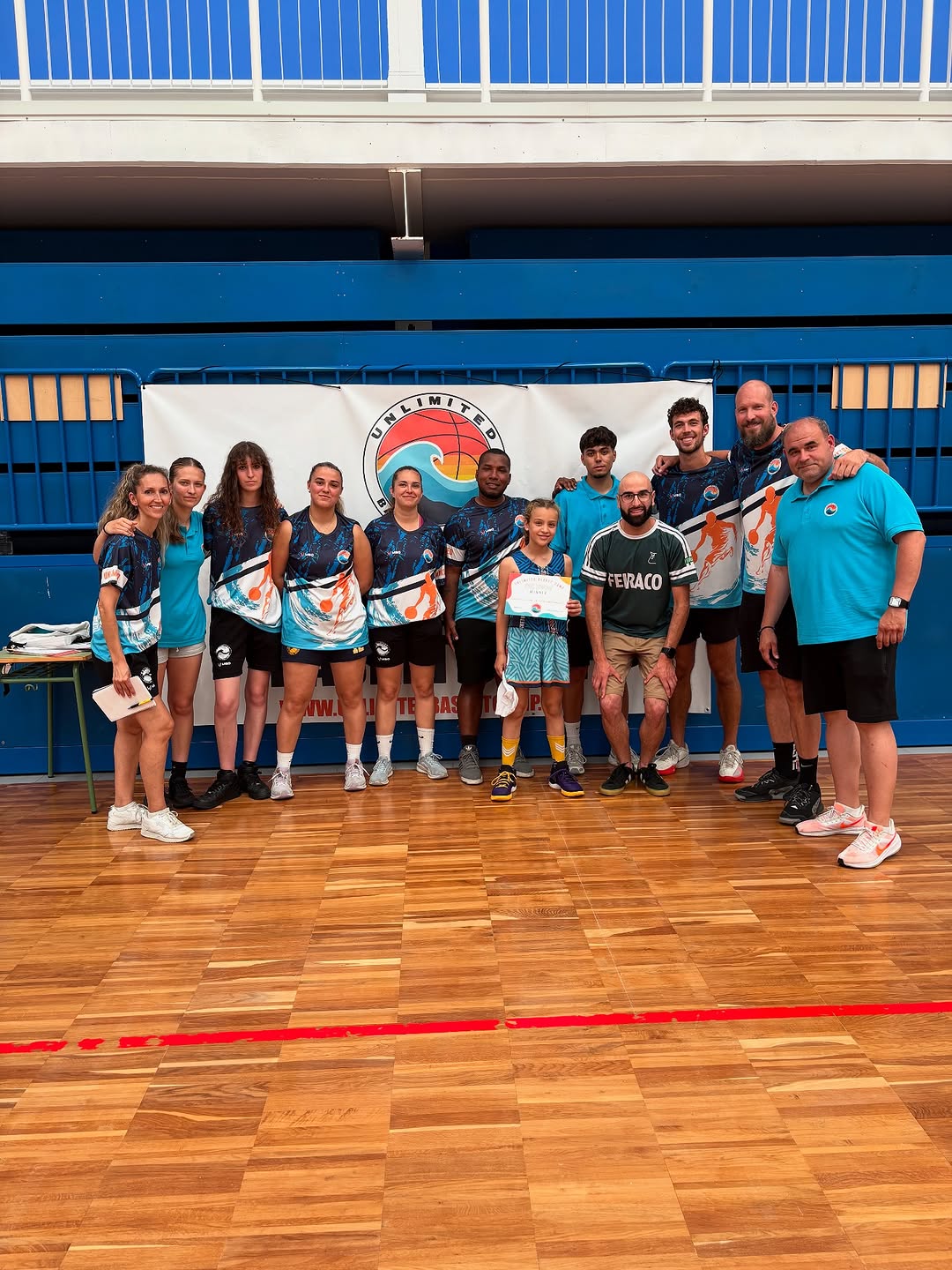 Grupo de jugadores y jugadoras en la pista, delante del photocall