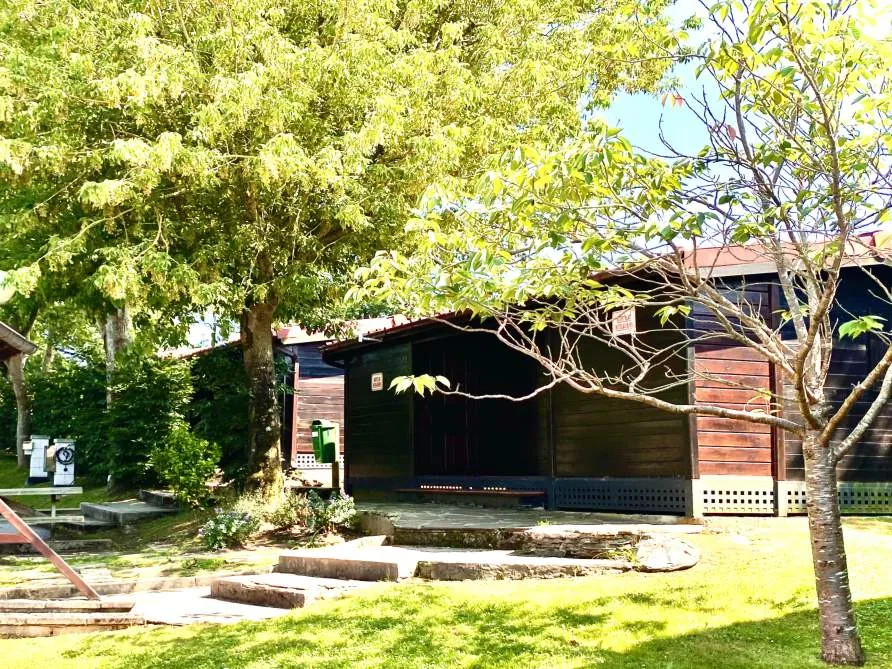 Jardín del Albergue Paradiso con una de sus cabañas de madera